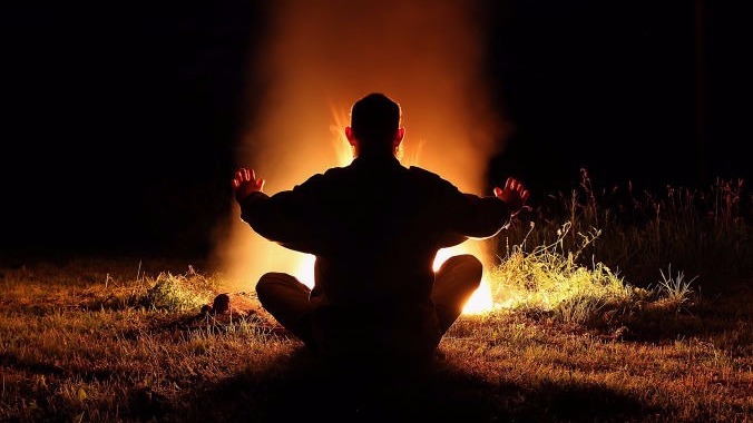 Uomo davanti al fuoco durante un rito sciamanico